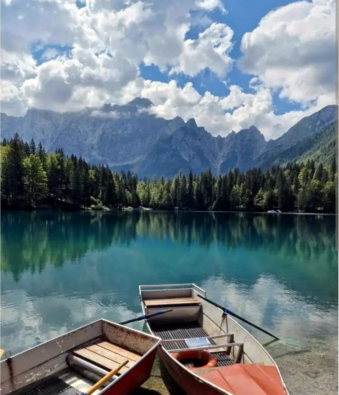 I Laghi di Fusine con le barche a riva e il Mangart sullo sfondo